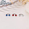 Three pairs of titanium steel nose rings featuring blue, red, and clear CZ crystals displayed on a white background.