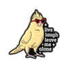 A yellow bird with red sunglasses and a humorous text design on an enamel pin.