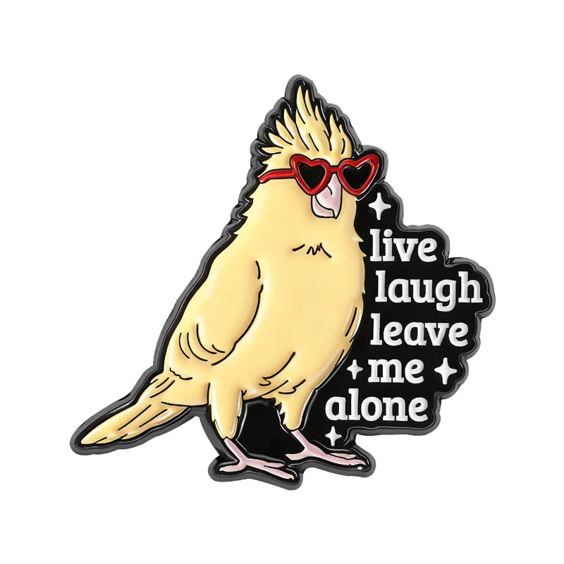 A yellow bird with red sunglasses and a humorous text design on an enamel pin.