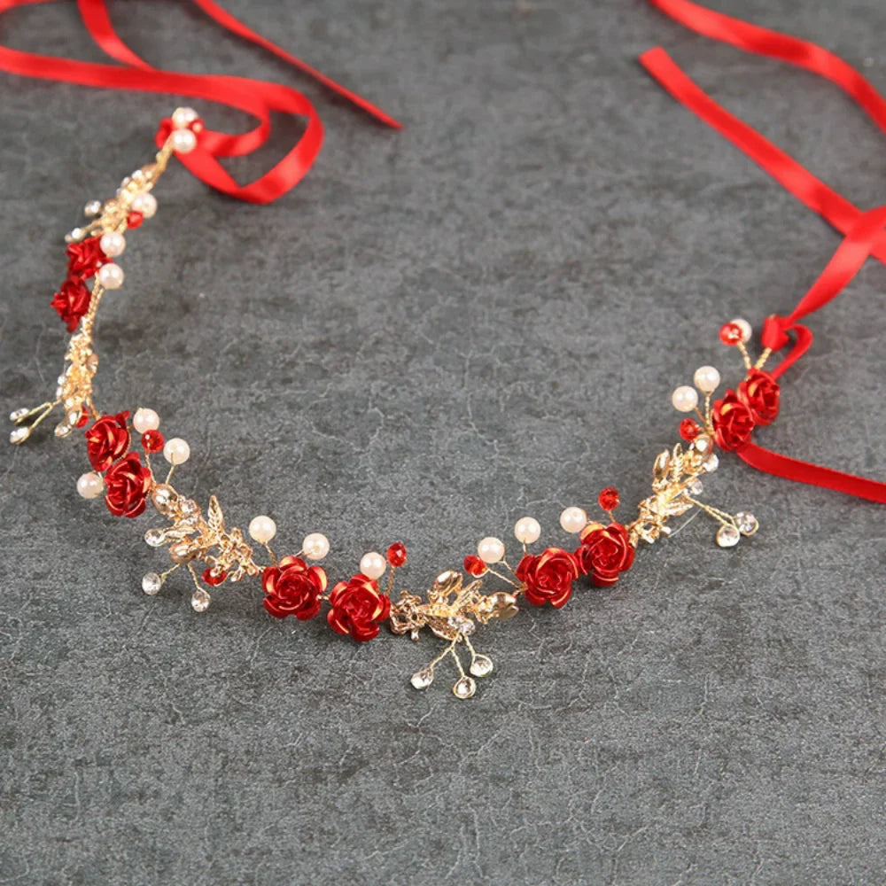 A delicate red rose pearl crystal headband with gold accents and a red ribbon.