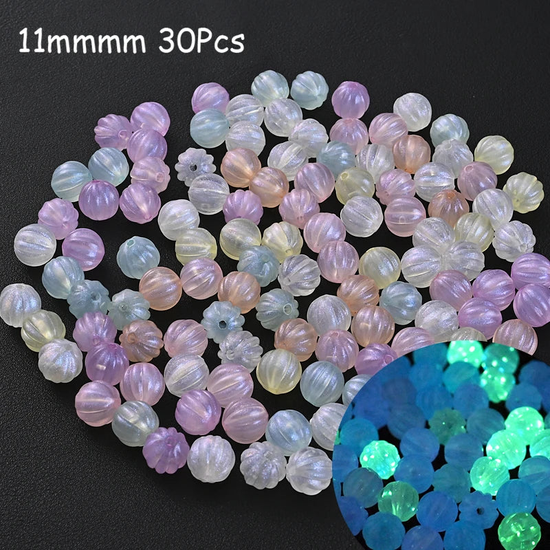 A collection of iridescent glow-in-the-dark acrylic beads in various shades of pink, purple, and blue.