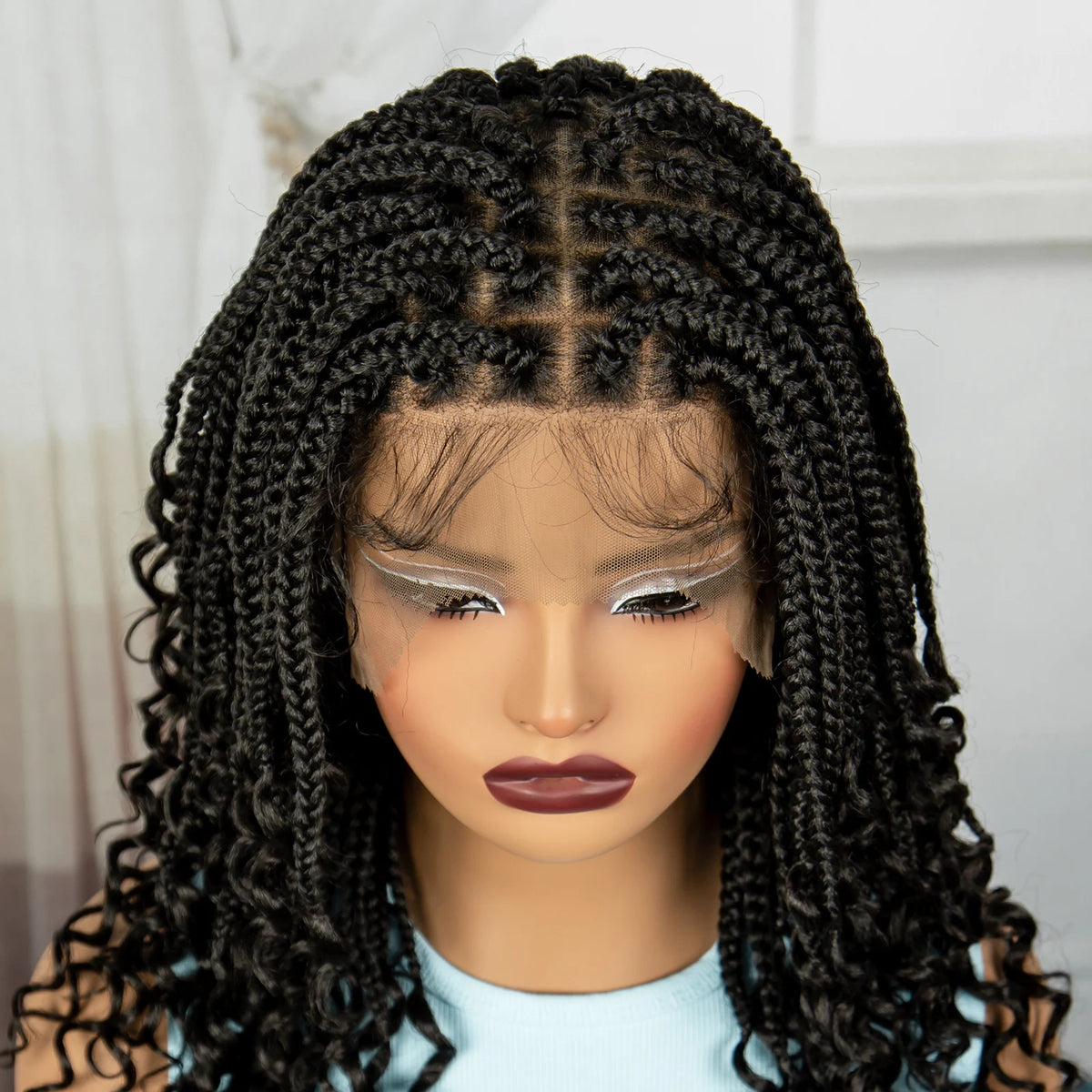 A close-up of a woman's head wearing a black boho box braid wig with silver highlights.