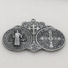 A silver Saint Benedict protection medal featuring a cross and Latin inscriptions for wall decor.