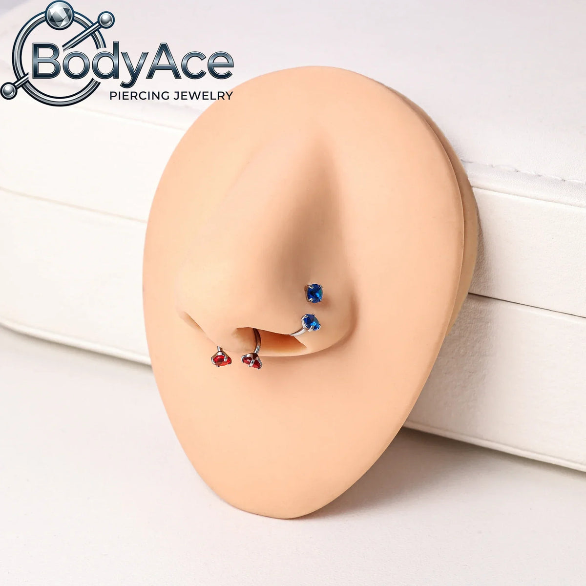 A close-up of a model's ear showing various titanium steel nose rings with CZ crystals.