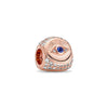 Rose gold charm pendant featuring a sunburst design and a blue gemstone surrounded by clear diamonds