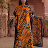 Une femme modélise une caftan abaya imprimé léopard zèbre orange et noir dans un cadre traditionnel.