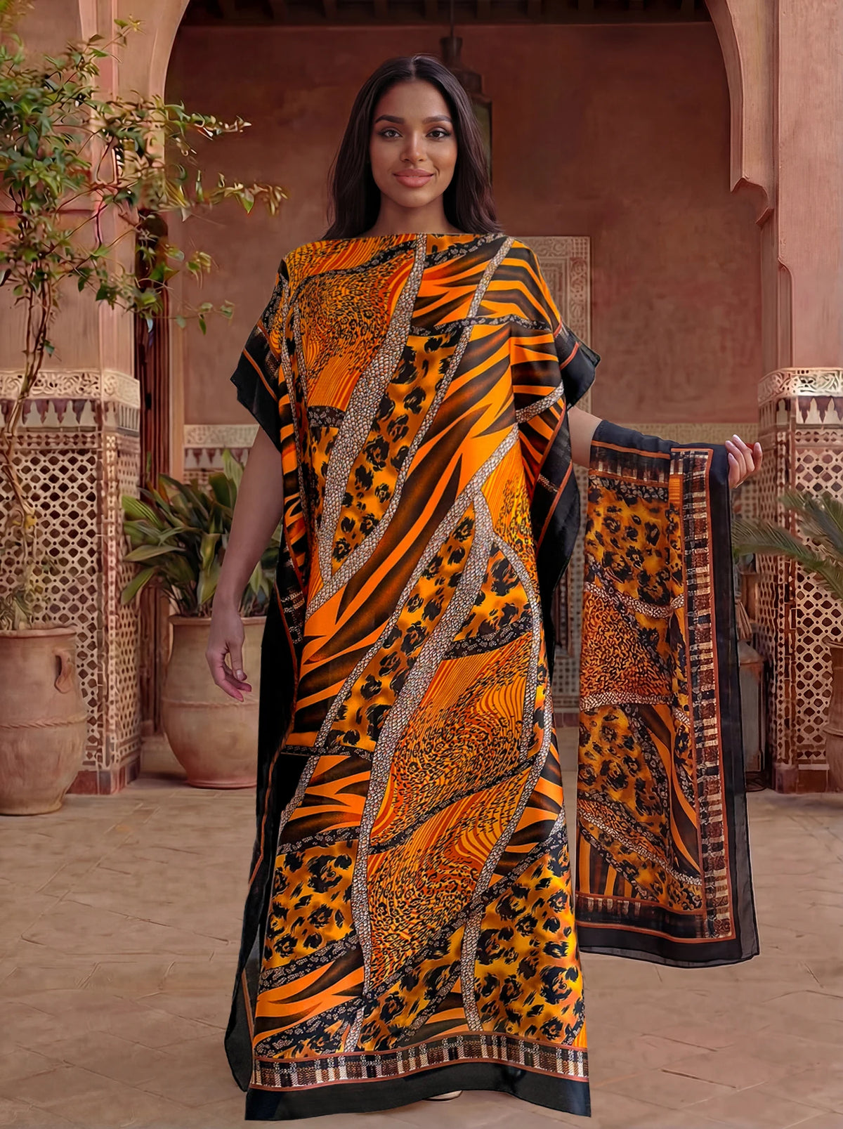Une femme modélise une caftan abaya imprimé léopard zèbre orange et noir dans un cadre traditionnel.