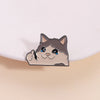 A cute enamel brooch pin of a cat with blue eyes and a smiling expression.