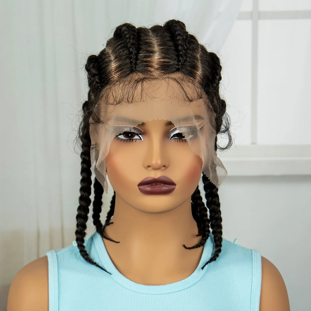 Un mannequin présente une perruque avec des tresses synthétiques brun foncé sur fond blanc.