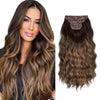 Una mujer modela cabello castaño ondulado y una extensión clip con estampado floral.