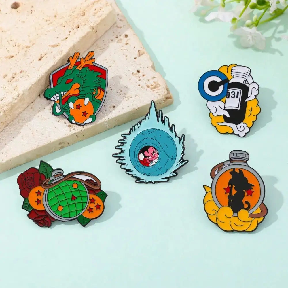 Ein Set von zwölf Emailpins mit Charakteren aus der Son Goku Master Roshi-Zeichentrickserie in verschiedenen Designs.