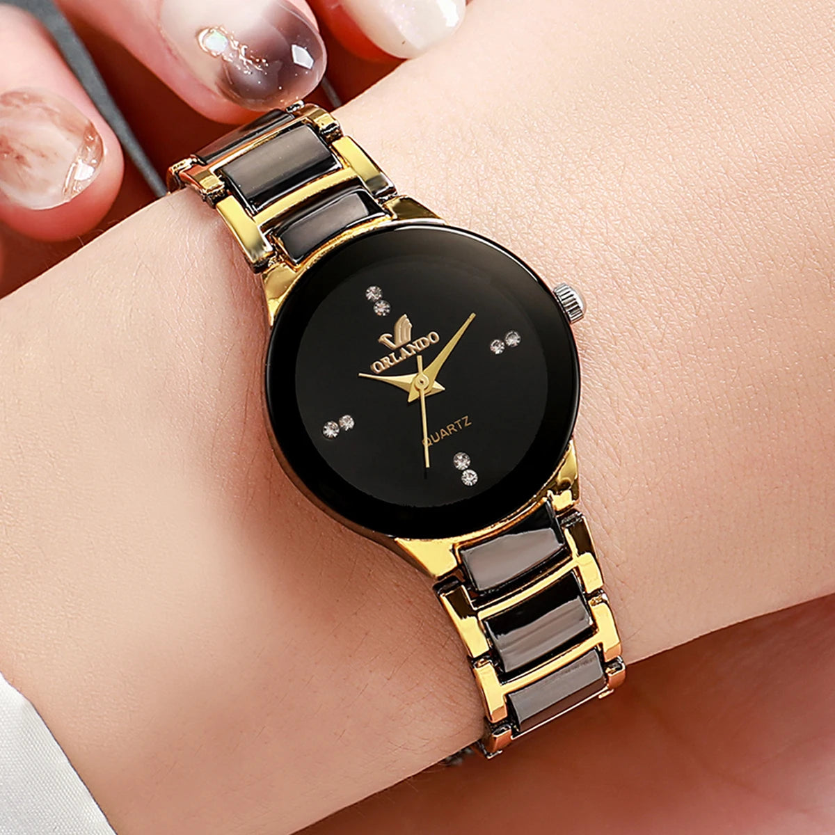 A close-up of a gold-toned analog watch with a black face and dark brown strap on a person's wrist.