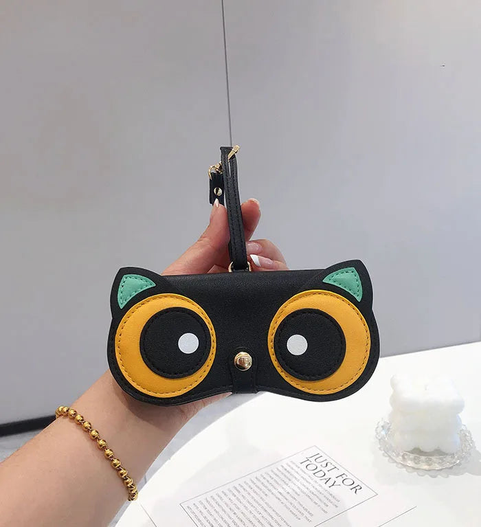 A hand holds a black pouch with yellow and white accents, designed for portable eyewear storage.