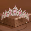 Diadema de tiara de cristal rosa brillante y transparente con detalles florales, mostrada en una caja marrón.