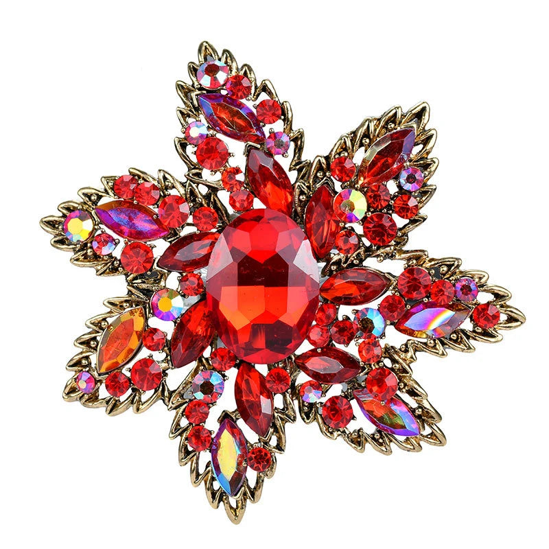 Broche fleur en cristal rouge et or scintillant avec de nombreuses pierres taillées.