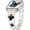 Gros plan d'une montre connectée argentée avec un affichage papillon coloré et un bracelet scintillant universel.