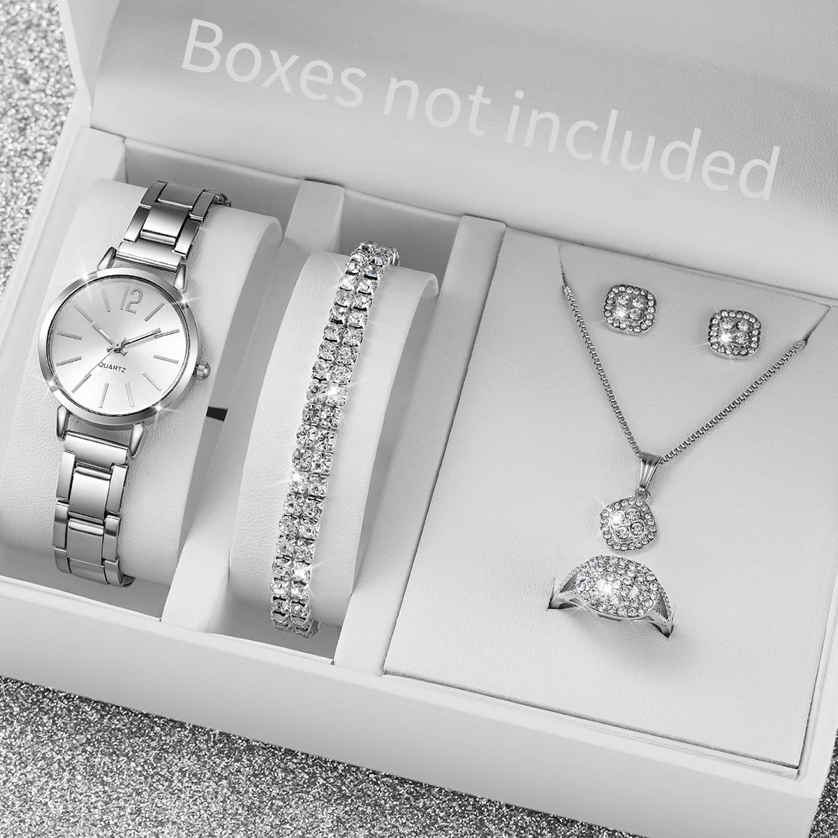 A white box contains an elegant quartz wrist watch, a diamond bracelet, and a diamond necklace.