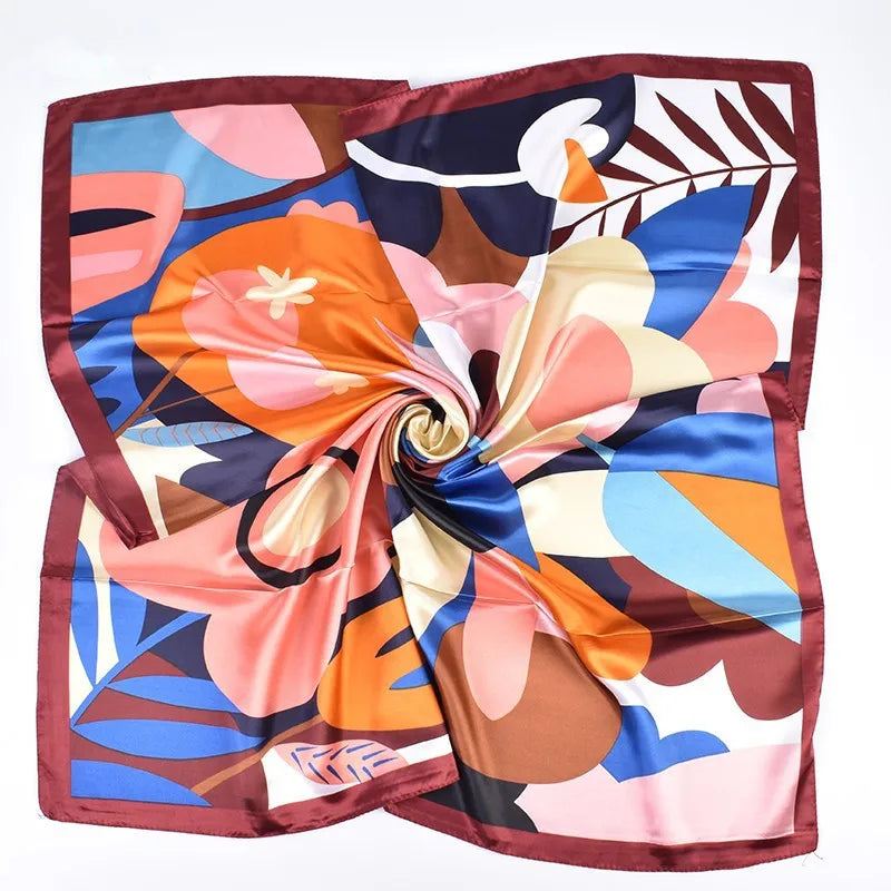 Luxuriäres Seidenschal aus Satin mit lebhaftem floralen und tropischem Muster in Pink, Orange, Blau und Braun.