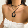 A black rope choker necklace worn around the neck against a skin tone.