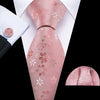 A close-up of a pink silk jacquard tie and matching shirt cuff set.