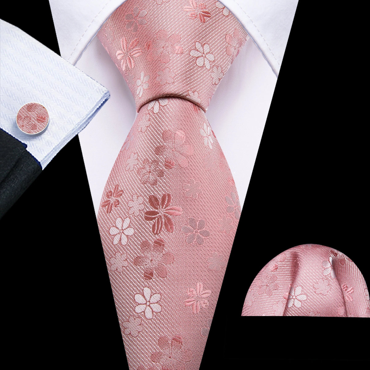 A close-up of a pink silk jacquard tie and matching shirt cuff set.