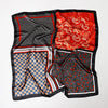 A luxury satin silk scarf featuring red, black, and gold patterns folded for display.