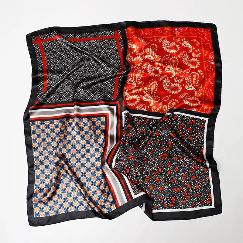 A luxury satin silk scarf featuring red, black, and gold patterns folded for display.