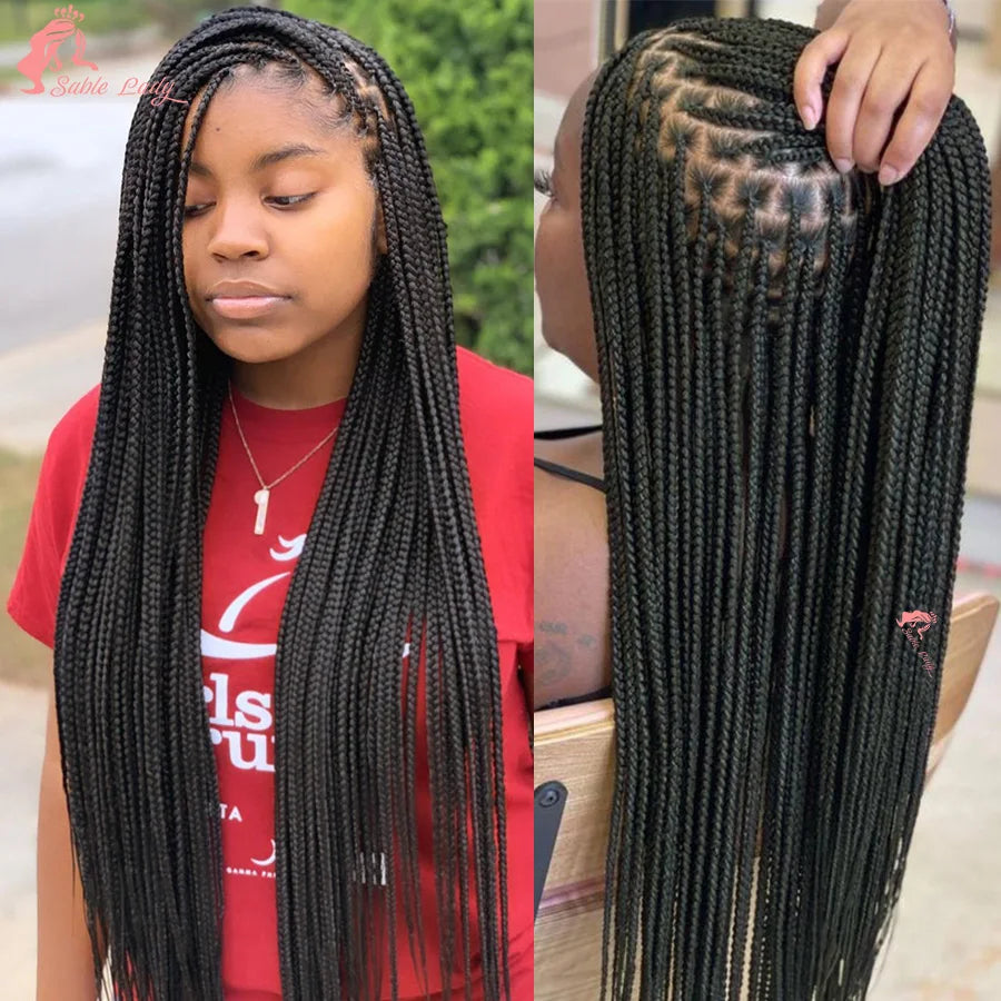 A woman shows off long black box braids on her hair.