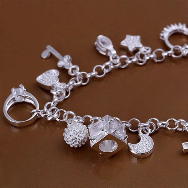 A silver geometric charm bracelet featuring various charms including hearts, stars, and a cube shape.