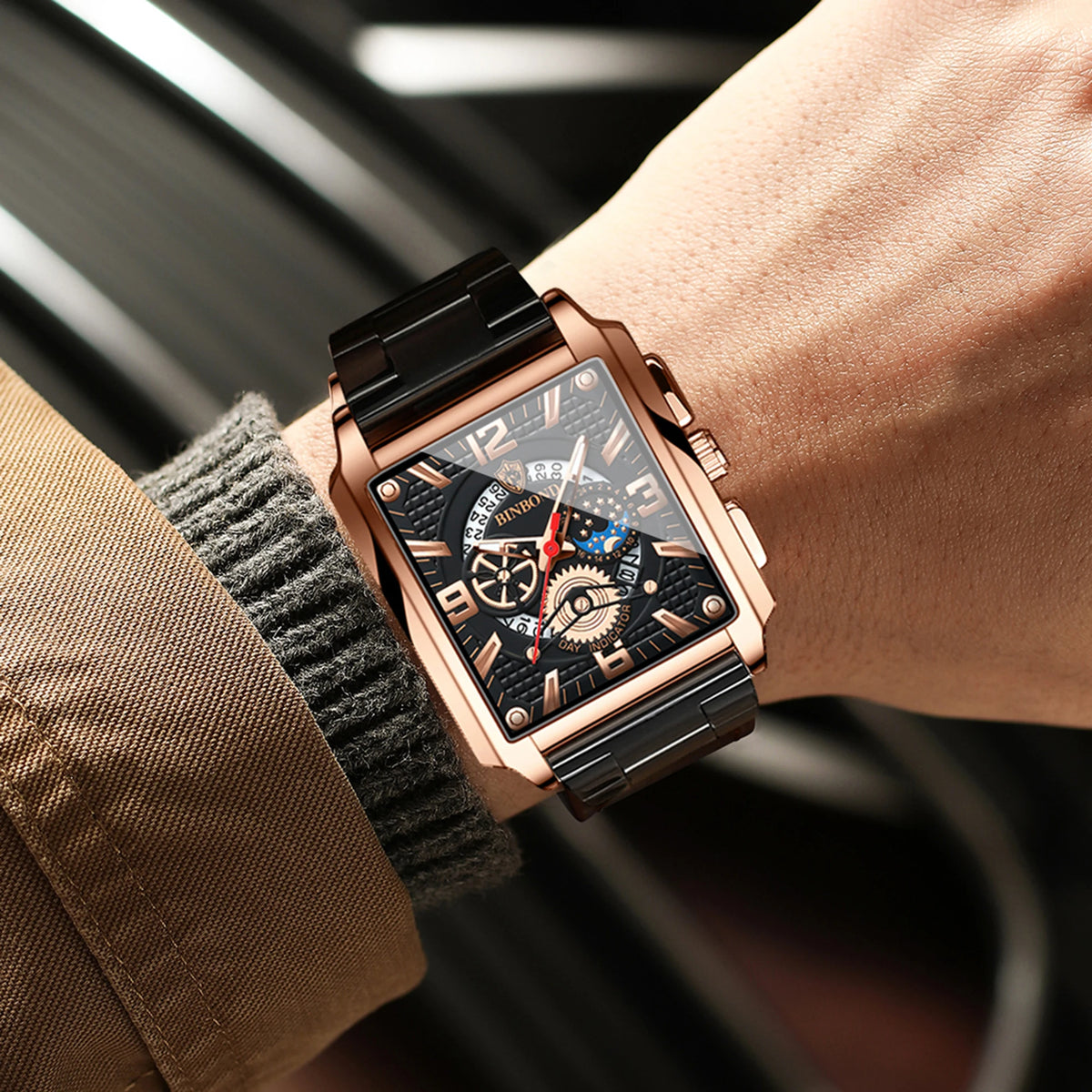 Nahaufnahme einer Roségold-Luxus-Quarz-Armbanduhr mit dunklem Zifferblatt und leuchtenden Merkmalen, getragen an einem Handge