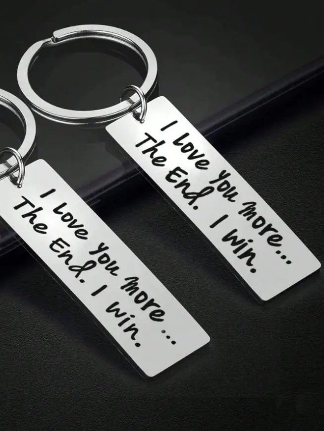 Silver keychain tags engraved with the message I Love You The End I win I Love You more I win