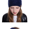 A collection of women wearing various knitted winter ear warmer beanies in shades of red, gray, and blue.