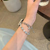 A close-up of a hand wearing a handmade transparent blue double chain watch strap.