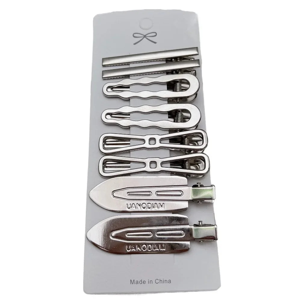 A set of vintage silver Y2K metal hair clips and pins displayed in a plastic case.