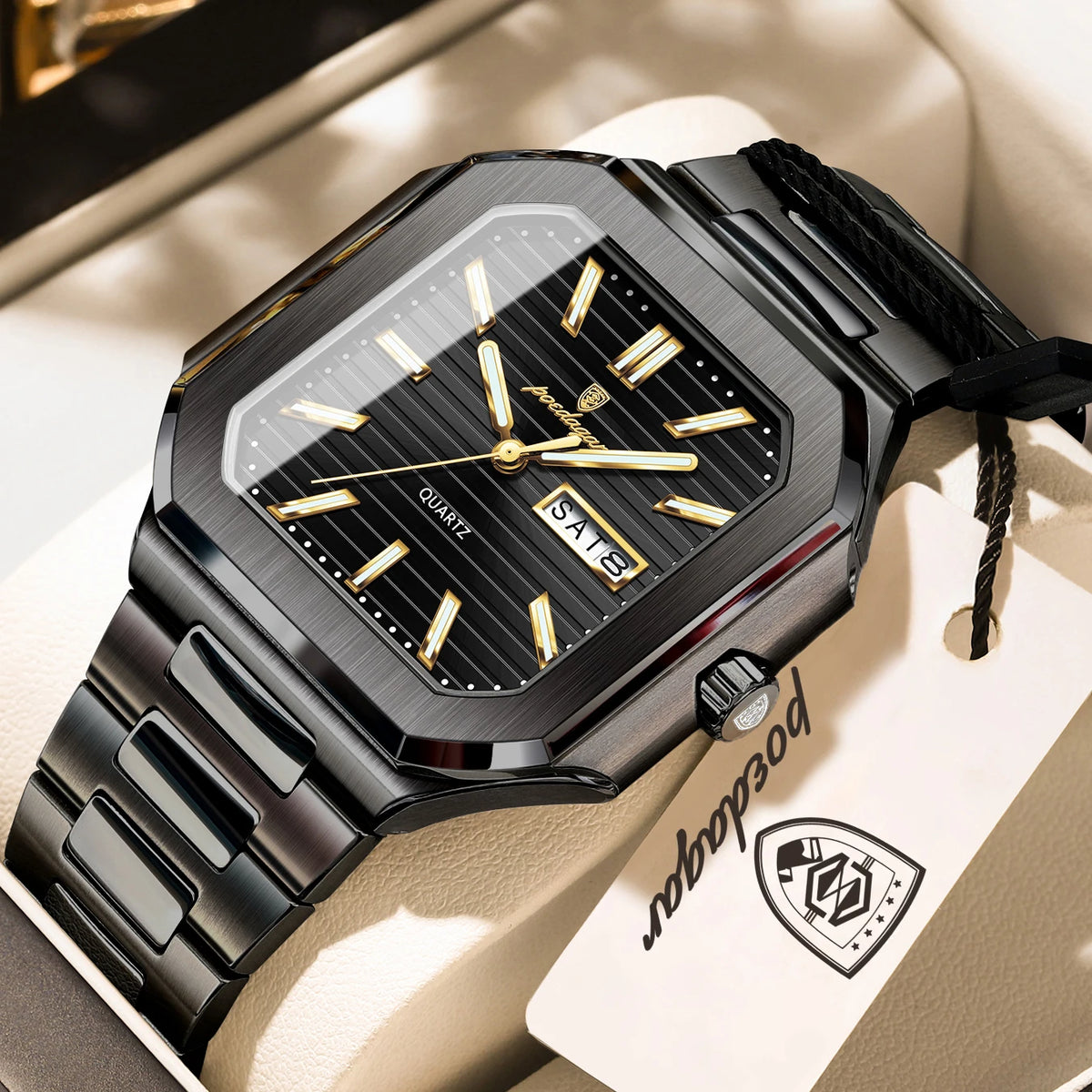 A black stainless steel watch with a gold-toned dial and bracelet resting on a light background.