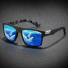 A pair of black polarized sunglasses featuring a vibrant blue ocean scene with a sailboat.