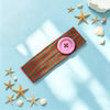 A pink polka dot button headband laid on a light blue surface with starfish and seashell decorations.