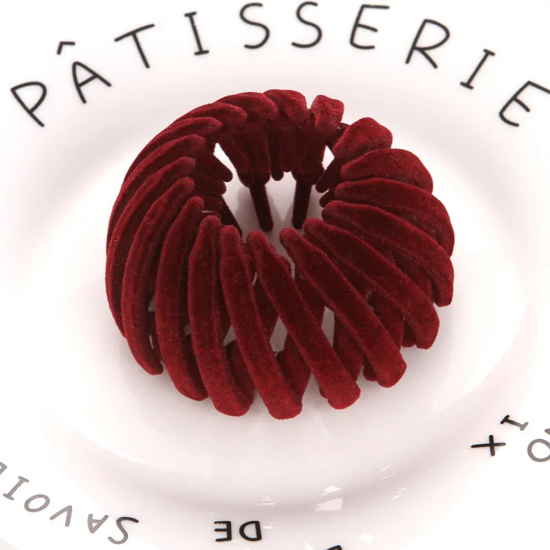 A circular arrangement of deep red velvet hair clips resembling horsetail hair for ponytails and buns.