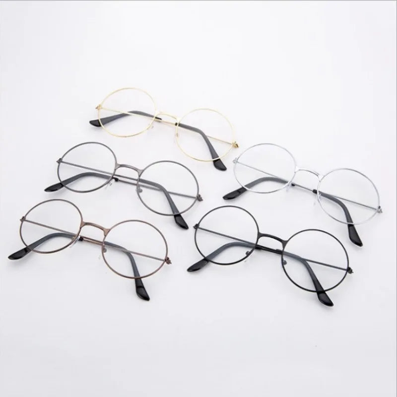 Colección de gafas redondas de metal en marcos dorados y negros sobre fondo blanco.