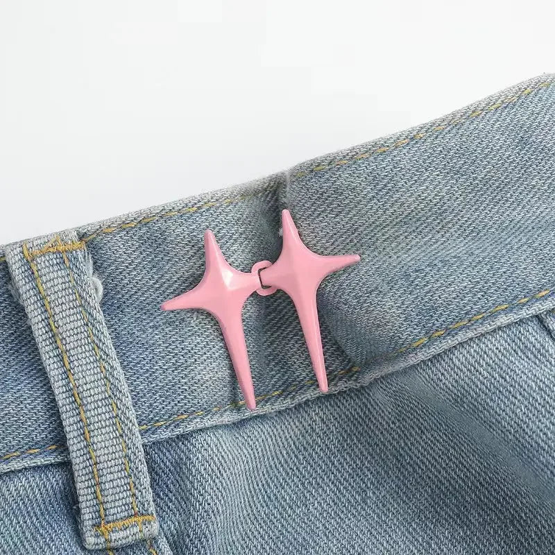 A pair of pink star-shaped decorative waist buckle buttons attached to a denim fabric.