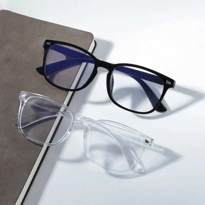 A pair of vintage square anti-blue light eyeglasses with dark frames and blue lenses resting on a gray surface.