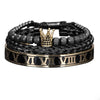 Una pila de pulseras de esmalte negro y dorado con diseños de números romanos y una corona.
