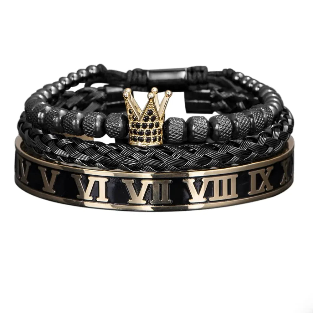 Una pila de pulseras de esmalte negro y dorado con diseños de números romanos y una corona.