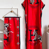 Una vibrante túnica abaya kaftan roja con elegante estampado de caballo blanco y negro.