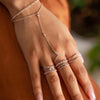A hand wearing a delicate sterling silver geometric bezel charm bracelet on a person's wrist.