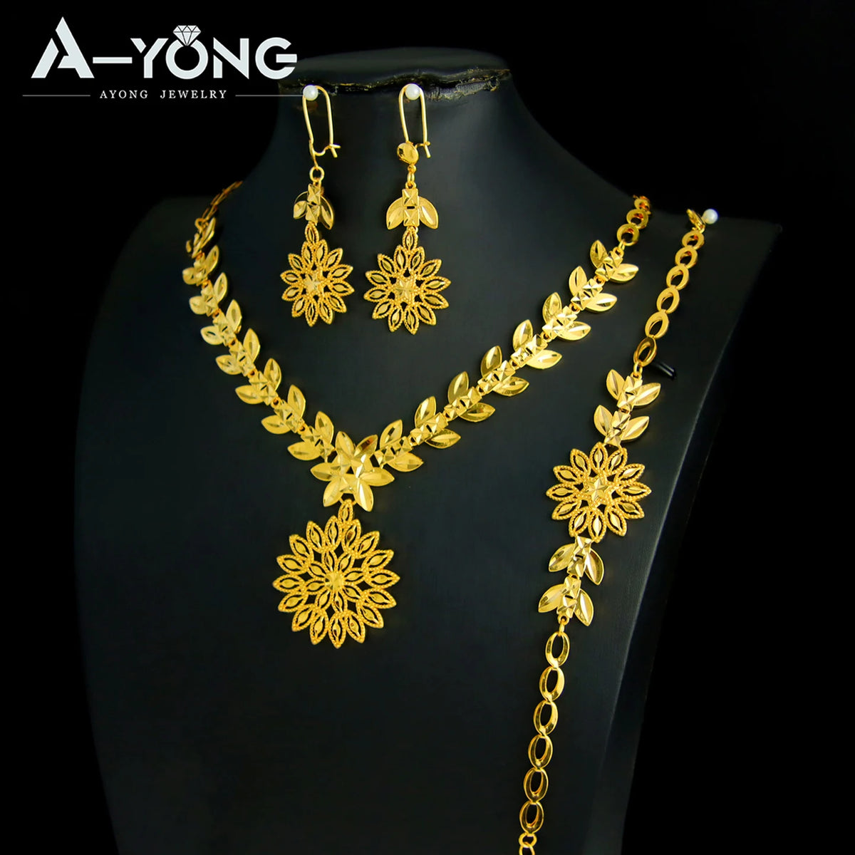 A set of luxury gold plated bridal jewelry featuring earrings and a necklace with floral designs.