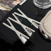 A set of vintage silver Y2K metal hair clips displayed on a black card.