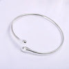 A silver adjustable stainless steel bangle with a droplet design shown against a white background.