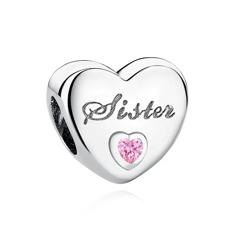 A heart-shaped sterling silver charm engraved with the word Sister and a pink gemstone.
