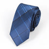 A dark blue striped skinny necktie folded and displayed against a white background.